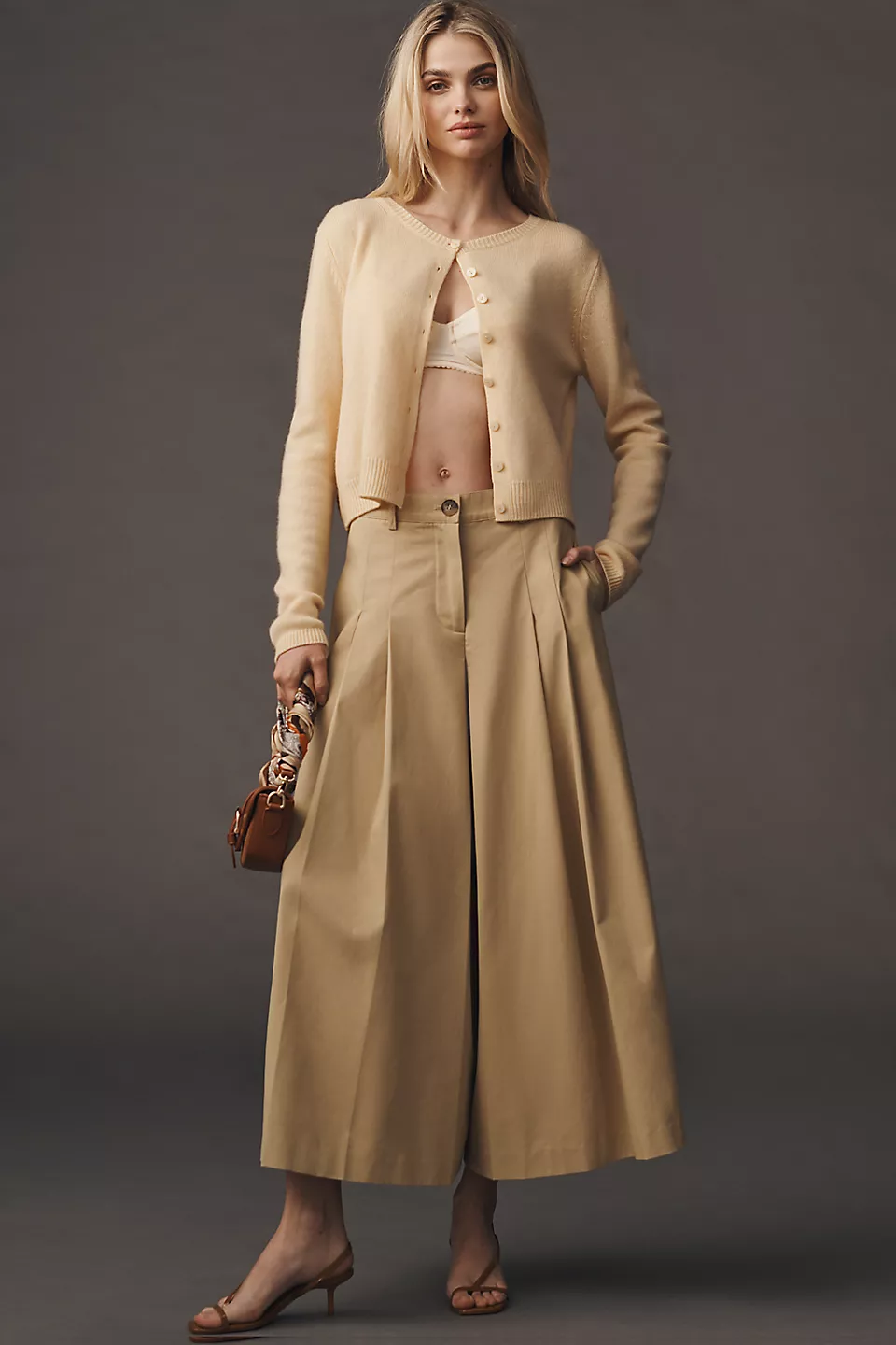 Khaki pleated culottes with a simple cardigan and heels on a model
