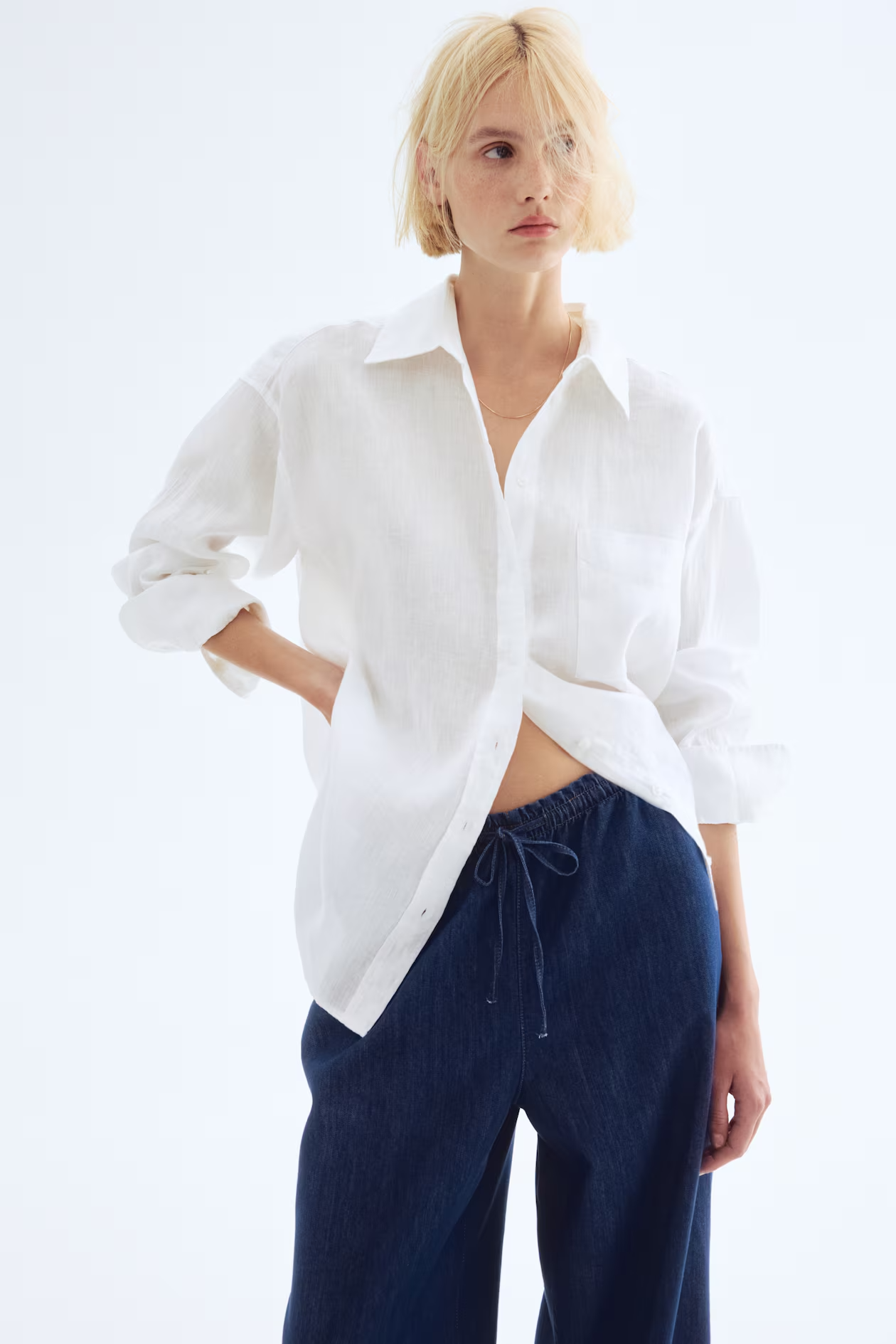 Oversized white button-down shirt with navy pants on a model