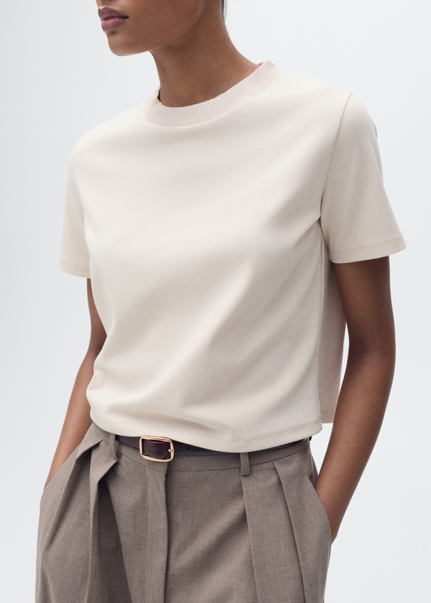 Beige cotton crewneck t-shirt with trousers and a belt on a model