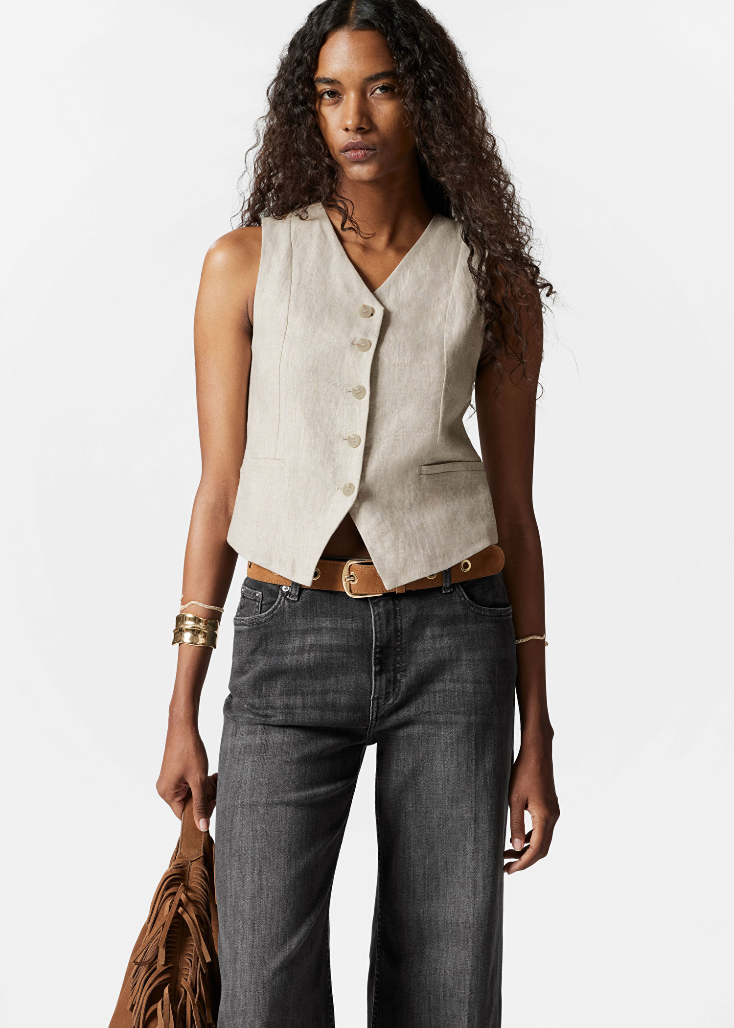 Oatmeal tailored vest with jeans and gold jewelry on a model