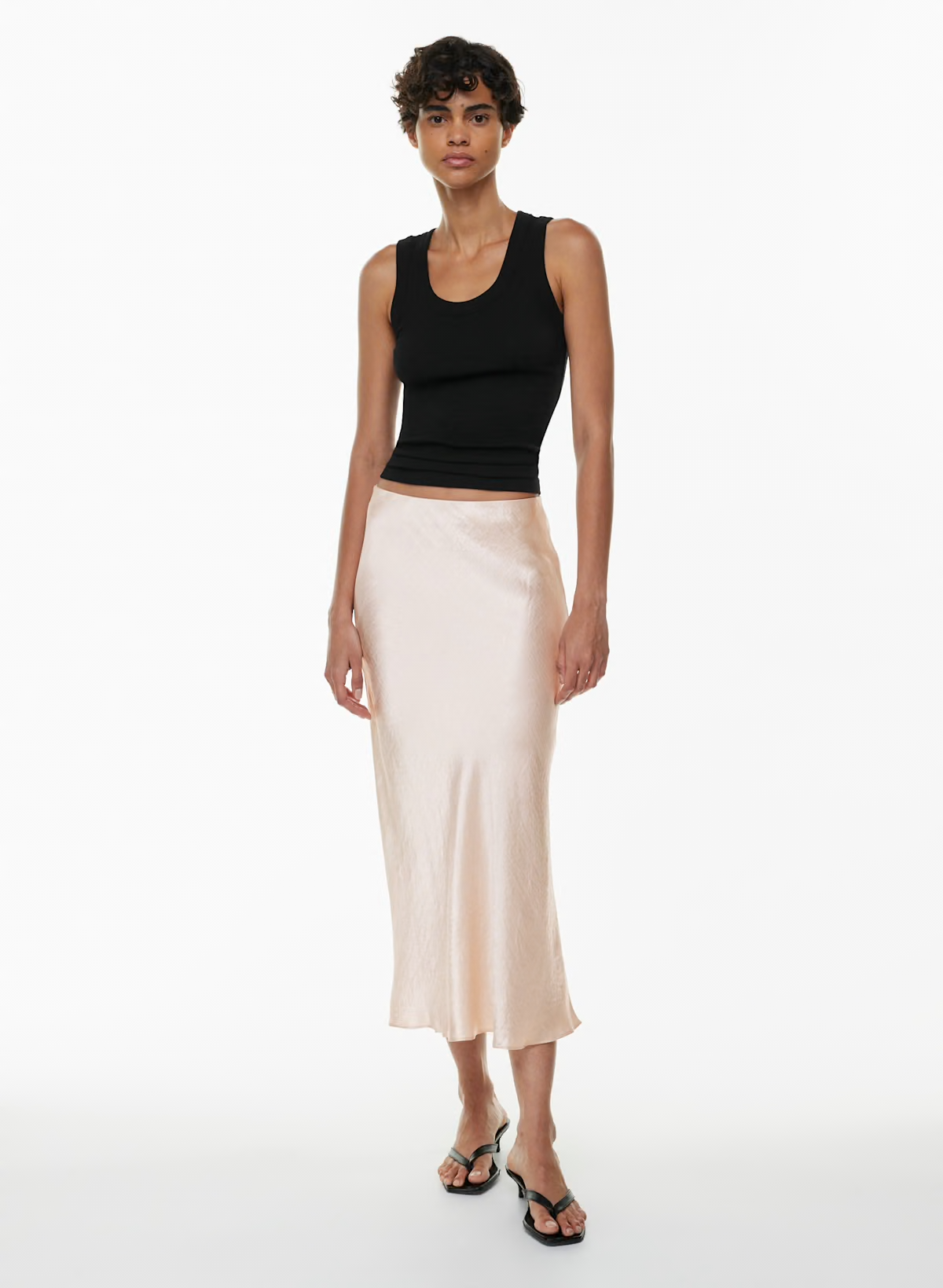 Light beige satin slip skirt styled casually with a basic tank top