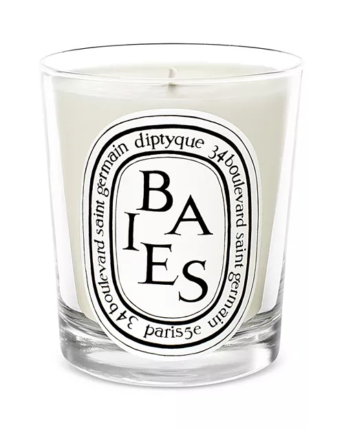 White candle with a black and white logo in a glass holder.