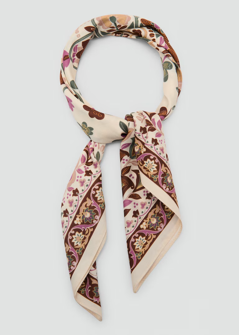 Cream and multicolored silk neck scarf tie in a knot.