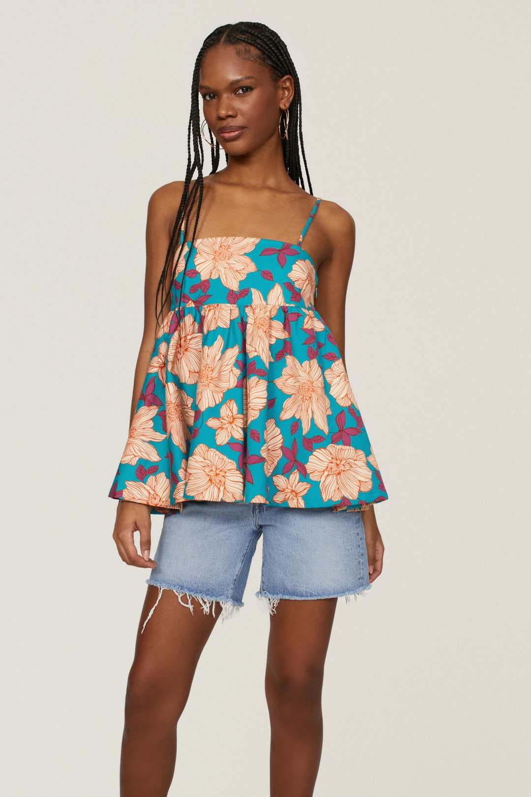 Turqoise and multicolored floral spaghetti strap flared tank top on a model.