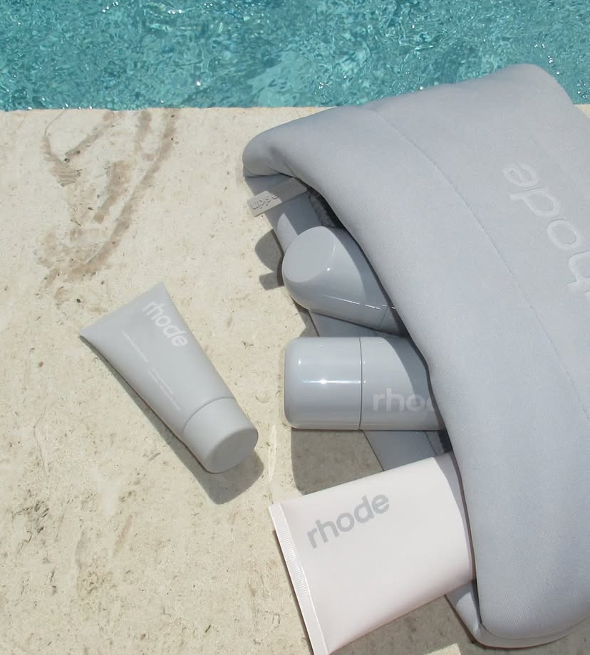 Rhode products in a gray bag and poolside for a summer glow-up