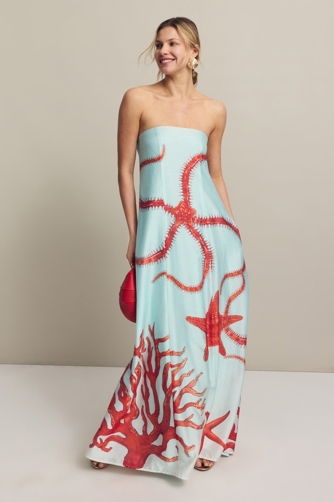 Turquoise silk strapless maxi dress with red sea creature print on a model.