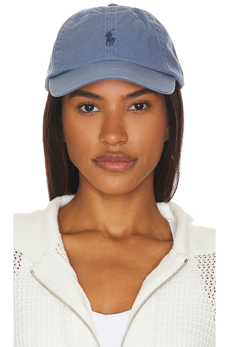 Blue washed cap with polo logo on a model.