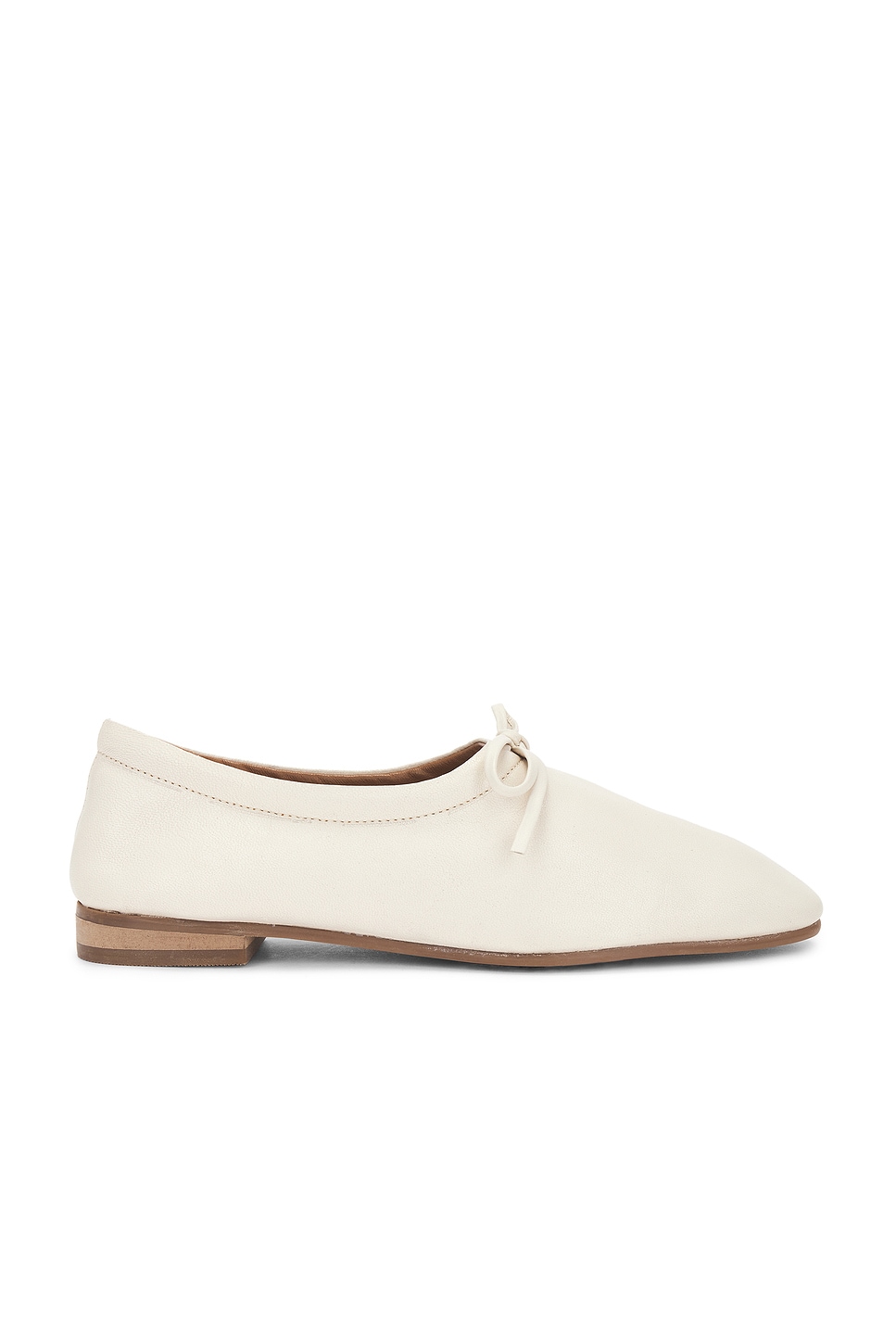 Cream loafers with a small heel and bow tie for stylish errand outfits.