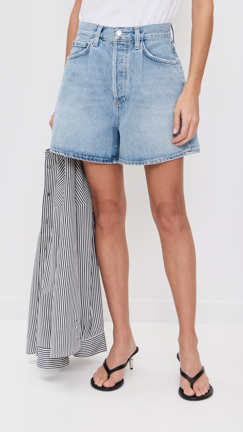 Light blue baggy mid-thigh denim shorts on a model.