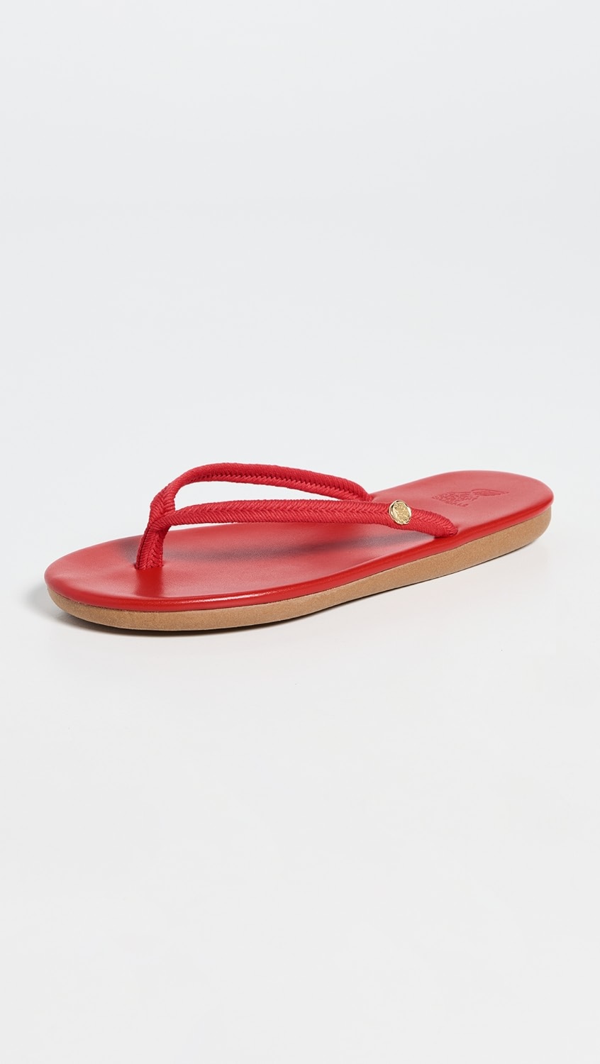 Red flip flop with tan sole and gold detail.