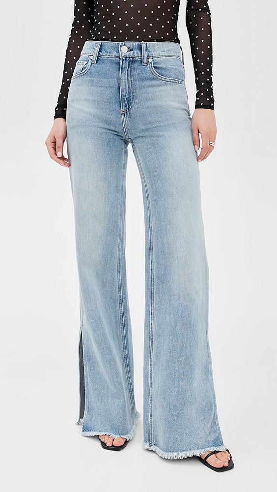 Blue denim jeans with slits on a model, which is one of the night out essentials.