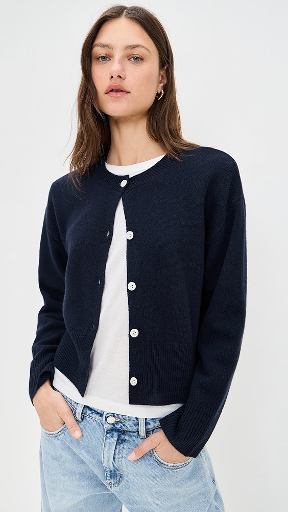 Navy cardigan with white buttons on a model.
