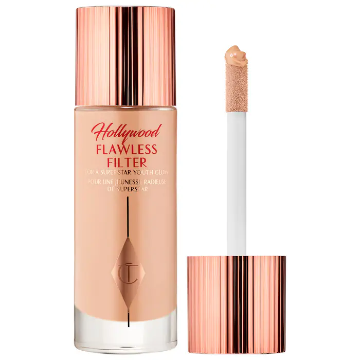 Rose gold makeup bottle with primer in it and an applicator.