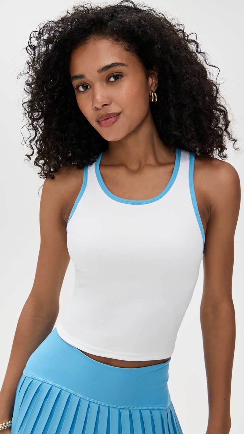 White tank top with turquoise trim on a model.