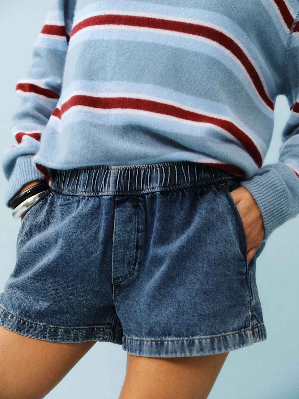 Blue denim pull on shorts on a model, which is one of the 4th of July fashion finds.