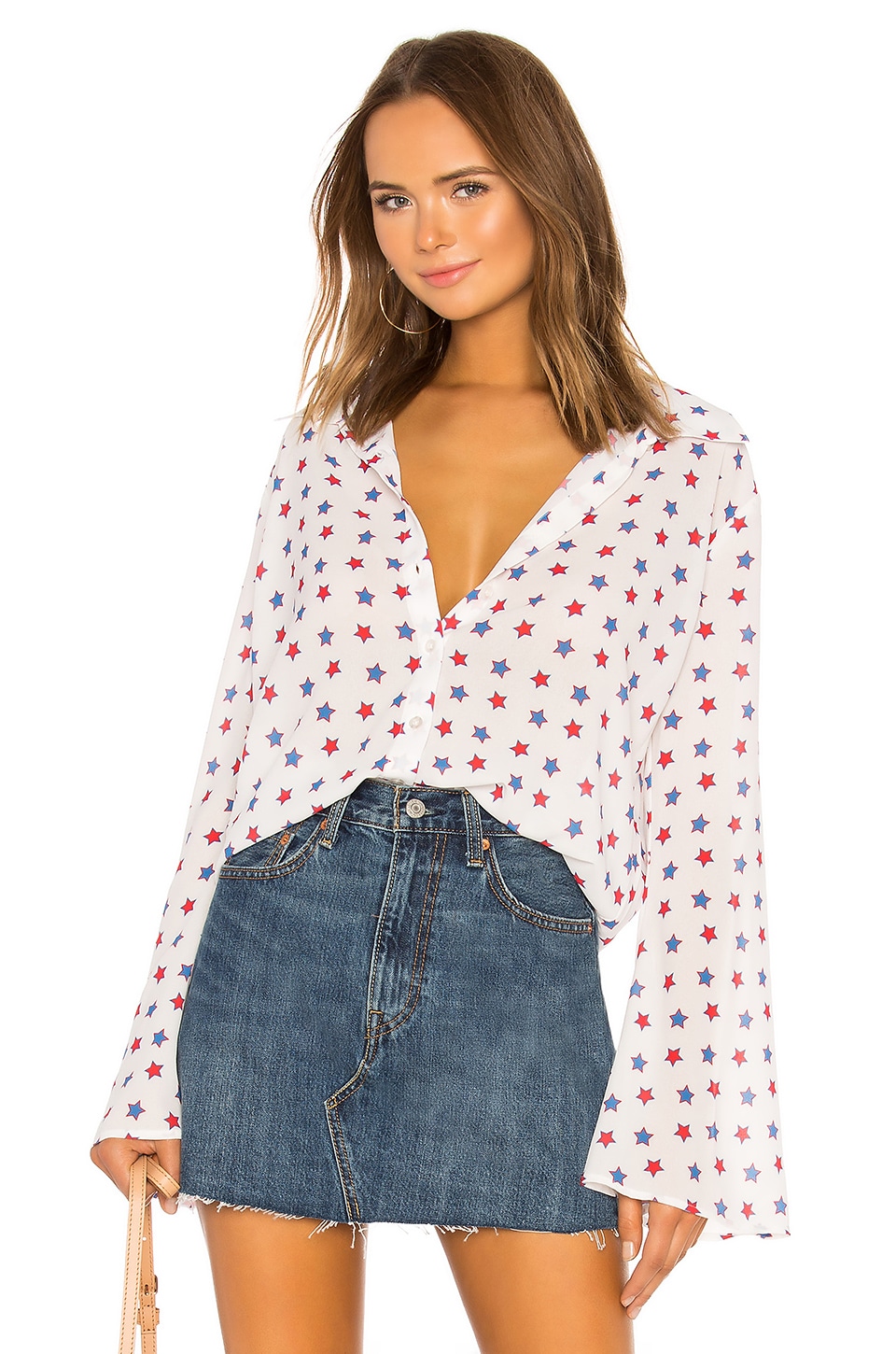 White blouse with red and blue stars on a model, which is one of the 4th of July fashion finds.