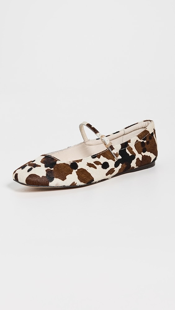 Brown, white, and black cow print ballet flats with a strap.
