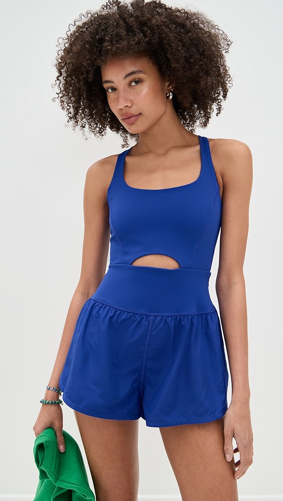 Blue active romper with a cutout on a model.