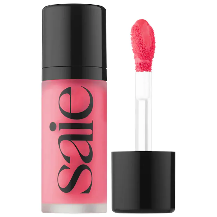 Clear and black Saie tube with an applicator of bright pink blush.