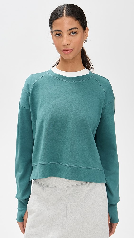 Blue green active crewneck on a model, which is one of the trendy activewear pieces.